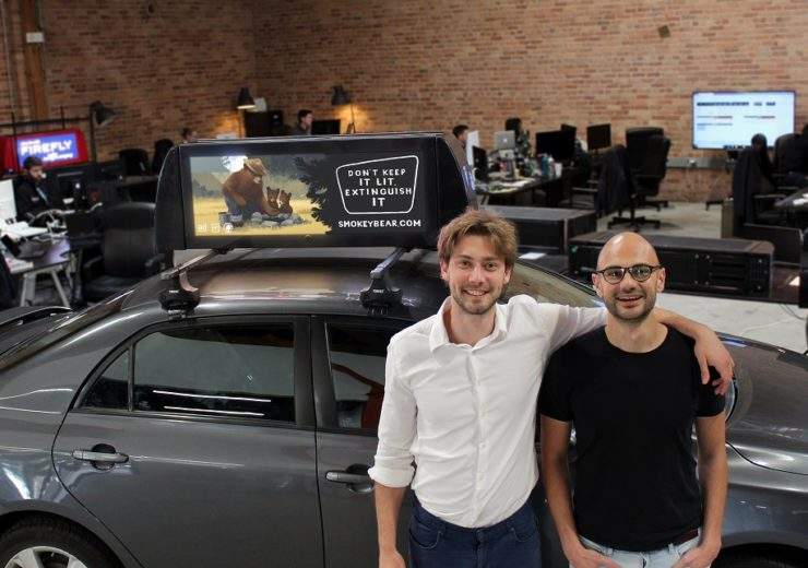 Firefly founders Kaan Gunay (CEO) & Onur Kardesler (CTO) in front of their on-car advertising screen